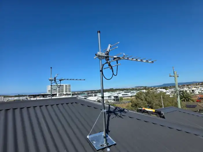 A newly installed digital TV antenna on a dark metal roof